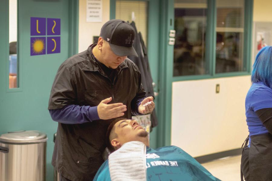 A 太阳集团娱乐场登陆网站 student preparing to put 剃须 cream on a man's face before a shave